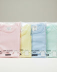 Stork And Baby pastel long sleeve baby vests in pink, yellow, blue, and mint green. 100% cotton.