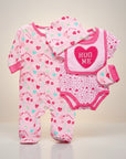 Stork And Baby pink 4-piece baby girl's outfit set with heart and candy prints, includes footie pajamas, bodysuit, bib with "Hug Me" detail, and hat.