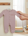 Stork And Baby pink 100% cotton interlock baby grow with snap closures and footies. Soft and breathable for everyday wear.