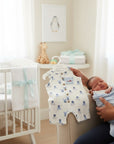 Stork And Baby white sleeveless romper with blue puppy print and button details, with matching knotty hat. Cotton blend.