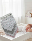 Stork And Baby 4 pack infant girls bandana bibs with unicorn and cloud print in pink, grey, and white. 100% cotton.