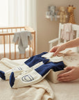 Stork And Baby navy and cream velour baby growers with a bowtie detail and embroidered pocket.