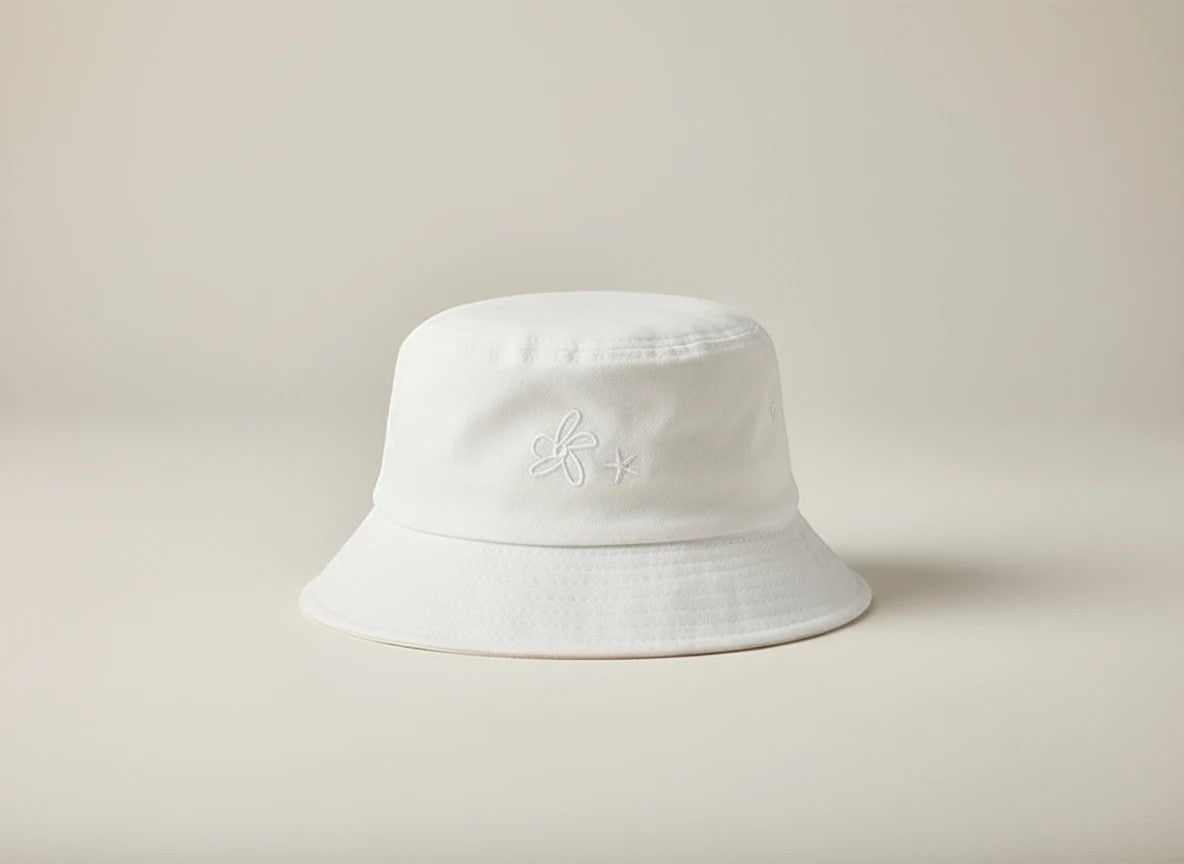 Stork And Baby white 100% cotton woven bucket hat with embroidered flower detail. Lightweight and breathable for baby.