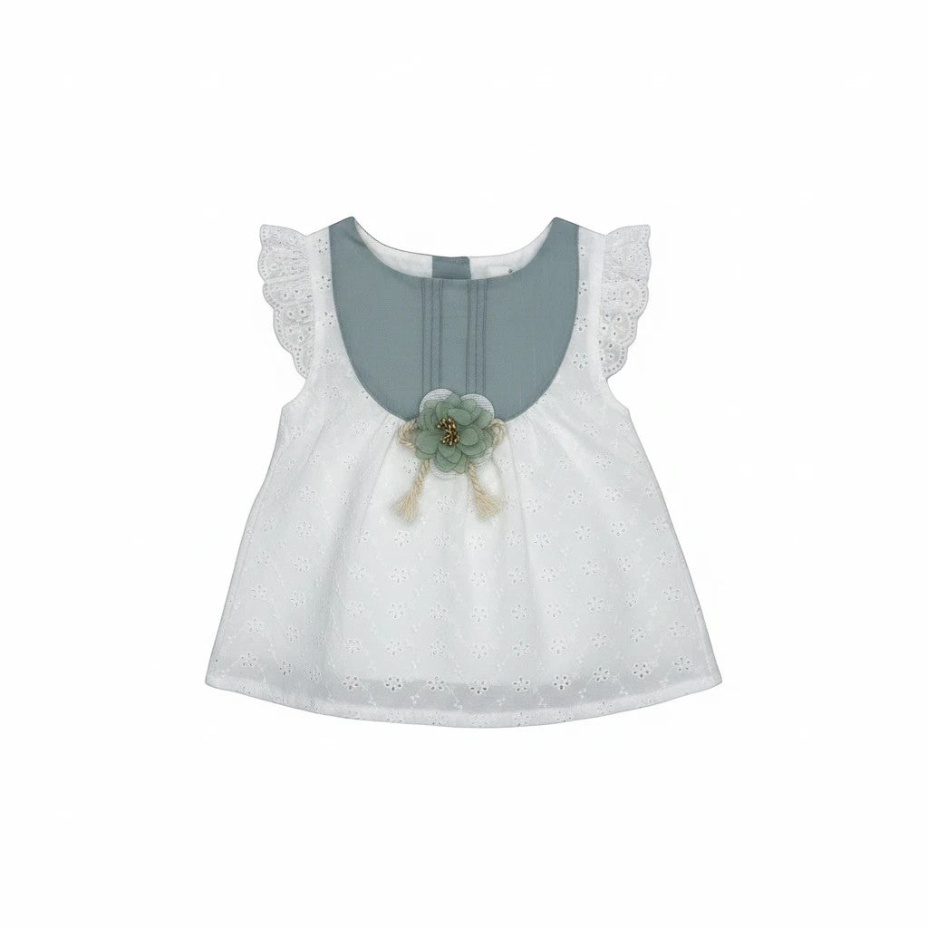 Stork And Baby white cotton linen dress with blue yoke, ruffled sleeves, and floral embellishment.