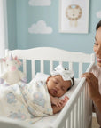 Stork And Baby white satin bow alice band with rose on a sleeping baby in a crib with a mother watching