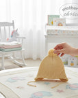 Stork And Baby yellow knitted trapper beanie with pom pom and ties, for babies.