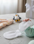 Stork And Baby white cotton baby mittens, soft and comfortable for newborns.